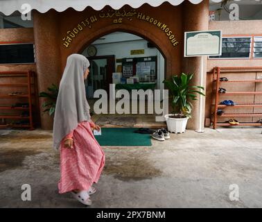 Ein thailändisches muslimisches Mädchen steht vor der Haroon-Moschee in Bang Rak, Bangkok, Thailand. Stockfoto