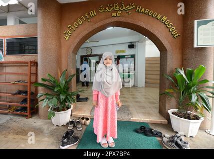 Ein thailändisches muslimisches Mädchen steht vor der Haroon-Moschee in Bang Rak, Bangkok, Thailand. Stockfoto