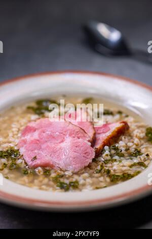 Brühe mit geräuchertem Fleisch und Grütze Stockfoto