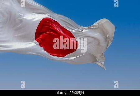 Japanische Nationalflagge, die an klaren Tagen im Wind wehte. Rote Scheibe auf weißem Feld. Japan ist ein Inselland in Ostasien. Realistische 3D-Darstellung. Stockfoto