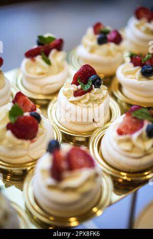Köstlicher Hochzeitsempfang, Süßigkeitenbar, Desserttisch mit verschiedenen Süßigkeiten, Cupcakes, Obst und Kuchen. Stockfoto