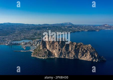 Luftaufnahme atemberaubende Penyal dIfac Naturpark von Penon de Ifach massiven Kalkstein auf dem Mittelmeer, vertäute Schiffe im Hafen von Calpe. Sunn Stockfoto