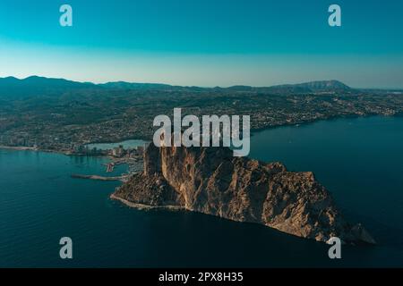 Luftaufnahme atemberaubende Penyal dIfac Naturpark von Penon de Ifach massiven Kalkstein auf dem Mittelmeer, vertäute Schiffe im Hafen von Calpe. Sunn Stockfoto