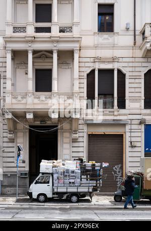 Ein Motorroller mit vielen Paketen über dem Dach steht vor einem historischen Stadthaus mit klassischer weißer Fassade in Palermo Italien. Stockfoto