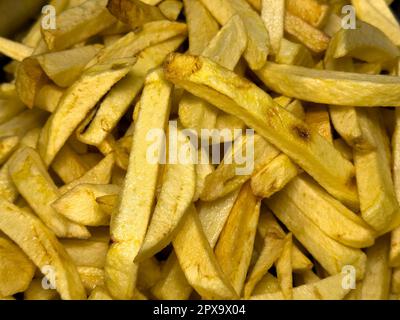 Pommes in Öl. Frisch gebackene Kartoffelchips. Lebensmittelhintergrund Stockfoto
