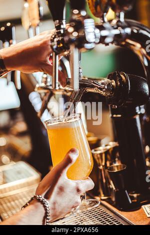 Eine verkürzte Hand Barkeeper, der Bier vom Fass an der Bar auffüllte. Stockfoto