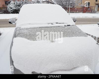 Schnee und Eis auf der Windschutzscheibe, den Rückspiegeln des Fahrzeugs. Winterliche Fahrbedingungen. Schneeräumen. Strassenverkehr im Winter. Metall Stockfoto