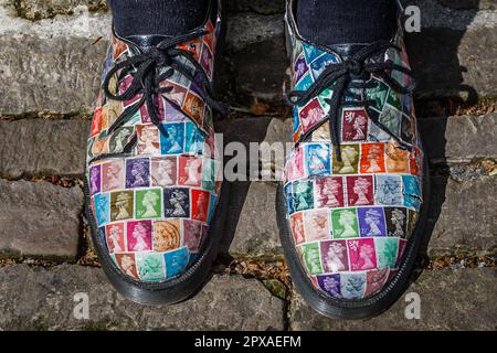 Ein Paar mit Briefmarken bedeckte Schuhe. Stockfoto