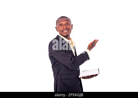 Porträt eines jungen Lehrers mit einem Notizbuch, das seine Lektion über Whiteboard Lächeln erklärt. Stockfoto