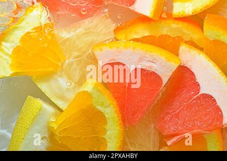 Frische Scheiben saftiger Grapefruit, Orangenfrüchte und Honigpomelo auf weißem Hintergrund. Grapefruitstücke, Orangenfrüchte und Honigpomelo mit Kohlensäure Stockfoto