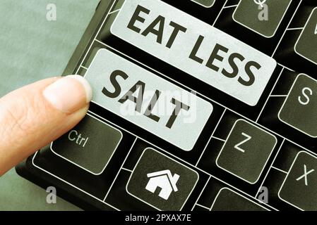 Schild mit der Aufschrift „Eat Less Salt“ (weniger Salz essen), Wort „Reducing the natrium intake“ (Reduzierung der Natriumaufnahme auf Lebensmitteln und Getränken Stockfoto