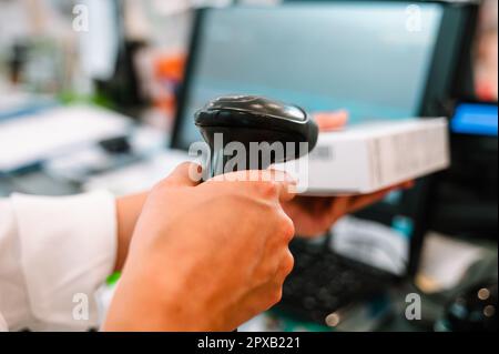 Der Apotheker verwendet einen Strichcodeleser, um ein Medikament zu identifizieren Stockfoto