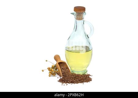 Leinsamenöl in Glasdekanter und Leinsamen in Holzschaufel in der Nähe von Flachsbäumen, isoliert auf weißem Hintergrund. Linum usitatissimum (Gemeiner Flachs) Stockfoto