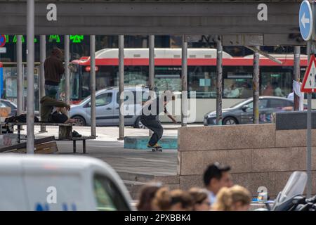 Junger alternativer Urban Skater in Action macht Spaß und zeigt Posen und Tricks auf dem Skateboard, bevor er mit seinen Freunden in Al in einem Straßenpark spaziert Stockfoto