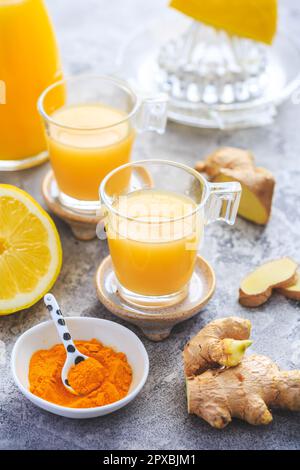 Hausgemachte Kurkuma Zitrone Ingwer Shots in kleinen Gläsern, gesunde Ingwer Zitrone Kurkuma Shot – ideal, um das Immunsystem im Winter zu stärken Stockfoto