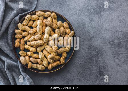 Ungeschälte Erdnüsse auf dem Küchentisch. Stockfoto