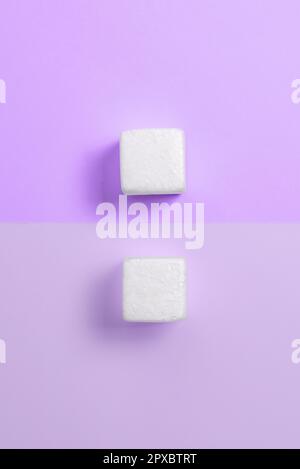 Weiße Styroporwürfel auf dem farbigen Schreibtisch. Brandneue Informationen. Stockfoto