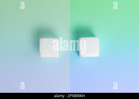 Weiße Styroporwürfel auf dem farbigen Schreibtisch. Brandneue Informationen. Stockfoto
