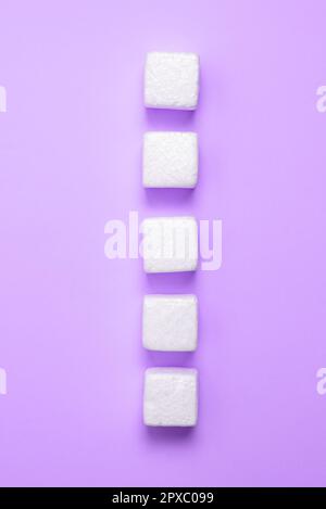 Weiße Styroporwürfel auf dem farbigen Schreibtisch. Brandneue Informationen. Stockfoto