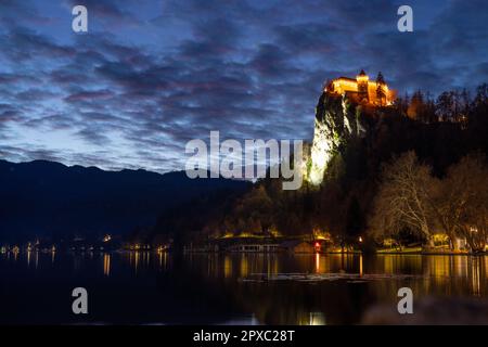 Dramatische Wolkenlandschaft über der mittelalterlichen Burg Bled hoch oben auf einer Klippe über dem See Bled bei Dämmerung, Slowenien Stockfoto