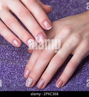 Schneewittchen-Maniküre an weiblichen Händen. Nageldesign für den Winter. Ein Foto im Studio Stockfoto