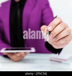 Mann in Jacke sitzt am weißen Tisch und zeigt mit Stift auf Nachricht. Stockfoto