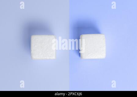 Weiße Styroporwürfel auf dem farbigen Schreibtisch. Brandneue Informationen. Stockfoto
