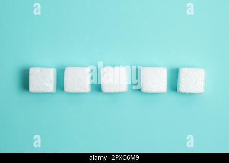 Weiße Styroporwürfel auf dem farbigen Schreibtisch. Brandneue Informationen. Stockfoto