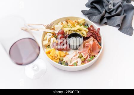 Weinteller mit Trauben, verschiedenen Käsesorten und Grissini Stockfoto