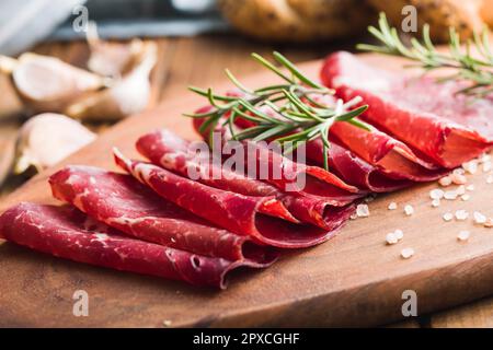 Geräucherte Bresaola. Italienische Vorspeise. Getrocknetes Rindfleisch auf dem Schneidebrett. Stockfoto