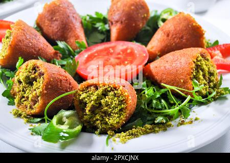 Icli Kofte gefüllte Fleischbällchen, eines der wichtigsten Gerichte der türkischen Küche, mit großartiger Präsentation Stockfoto