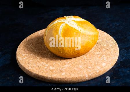 Frisches Weißbrot und Milch in weißem Glas auf schwarzem Steintischhintergrund. Draufsicht, Croissant Stockfoto