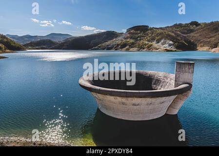 Damm-Spillway-Trichter über der Wasseroberfläche des Sees Stockfoto