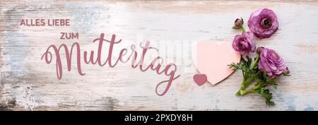 Muttertagskarte mit violetten Ranunculus-Blumen auf altem Holz. Horizontaler Hintergrund mit deutschem Text. Draufsicht. Stockfoto