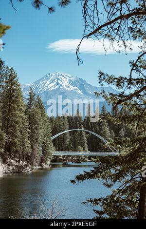 Die Fußgängerbrücke Wagon Creek in Siskia County, Kalifornien, ist mit majestätischen Bergen im Hintergrund ein atemberaubendes Bild Stockfoto