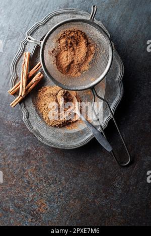 Aromatische Zimtstäbchen und Pulver auf grauem rustikalem Hintergrund – Nahaufnahme Stockfoto