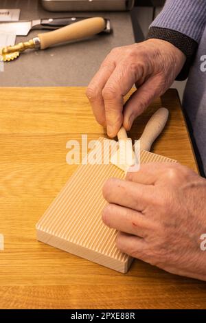 Herstellung hausgemachter Nudeln – italienische Nudeln (Tortiglioni) in heimwerkerarbeit – Nahaufnahme der Hände, die den Teig Rollen, um selbst zubereitete Tortiglioni zuzubereiten. Stockfoto