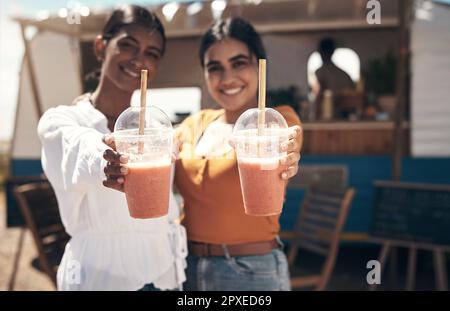 Zwei Freunde, die die Sonne genießen. Zwei Freunde genießen Smoothies zusammen. Stockfoto