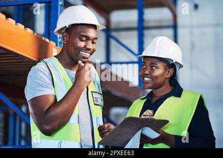 Ich habe vielleicht eine Idee zu Materialien. Zwei junge Fremdfirmen stehen im Lager und führen während der Bestandsaufnahme ein Gespräch. Stockfoto