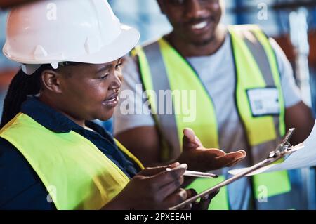 Wo soll ich die hintun? Zwei junge Fremdfirmen stehen im Lager und führen während der Bestandsaufnahme ein Gespräch. Stockfoto