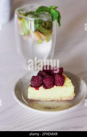 Himbeerkuchen und alkoholfreier Mojito im Café. Sommeressen. Stockfoto