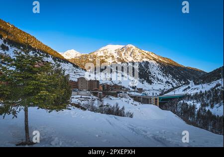 Soldeu Dorf mit Bergkette, beleuchtet von Sonnenuntergang im Hintergrund. Skiurlaub im Winter in Andorra, Grandvalira, Pyrenäen Stockfoto