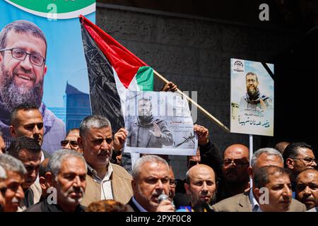 Gaza, Palästina. 02. Mai 2023. Die Menschen versammeln sich vor dem Gebäude des Internationalen Komitees vom Roten Kreuz (IKRK) in Gaza-Stadt, während sie das Poster des palästinensischen Gefangenen Khader Adnan halten, der nach einem 87-tägigen Hungerstreik in einem israelischen Gefängnis am 02. Mai 2023 starb. Khader Adnan trat als Reaktion auf seine administrative Inhaftierung 66 Tage im Jahr 2012, 52 Tage im Jahr 2015, 59 Tage im Jahr 2018 und 25 Tage im Jahr 2021 in den Hungerstreik. Foto: Ramez Habboub/ABACAPRESS.COM Kredit: Abaca Press/Alamy Live News Stockfoto