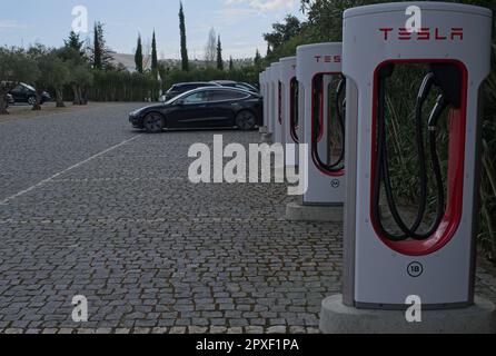 Montemor-o-Novo, Portugal - 1. April 2023: Statische Aufnahme eines soliden schwarzen Tesla Model 3 Dual Motor, der am Montemor-o-Novo Supercharger in A s aufgeladen wird Stockfoto