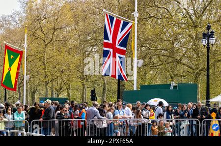 Vorbereitungen für die Krönung am 30. April 2023 mit den Flaggen von Grenada und Union Jack Commonwealth mit Leuten entlang der Mall London UK Stockfoto