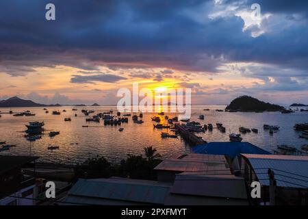 Sonnenuntergangsatmosphäre rund um das Wasser und den Hafen von Labuan Bajo, einem der wichtigsten Reiseziele in Indonesien. Viele Schiffe verschiedener Typen sind geparkt an Stockfoto