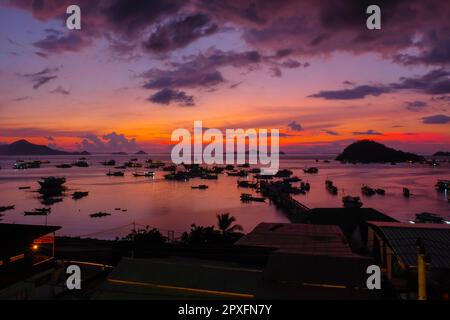 Sonnenuntergangsatmosphäre rund um das Wasser und den Hafen von Labuan Bajo, einem der wichtigsten Reiseziele in Indonesien. Viele Schiffe verschiedener Typen sind geparkt an Stockfoto