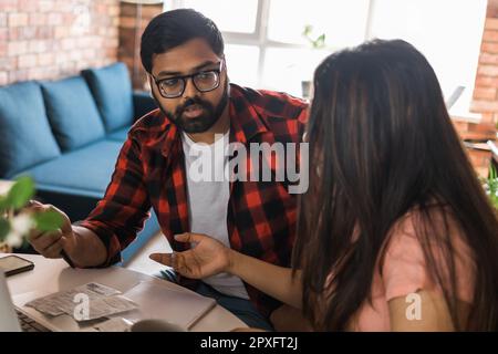 Ernsthafte Ehefrau und Ehemann planen Budget, prüfen Finanzen, fokussierte junge Frau mit Online-Rechner, Rechnungen oder Steuern zählen, Mann mit Laptop, o Stockfoto