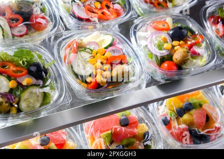 Kunststoffschachteln mit vorverpackten Gemüsesalaten, in Aufmachungen für den Verkauf in einem handelsüblichen Kühlschrank Stockfoto