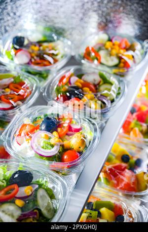 Kunststoffschachteln mit vorverpackten Gemüsesalaten, in Aufmachungen für den Verkauf in einem handelsüblichen Kühlschrank Stockfoto